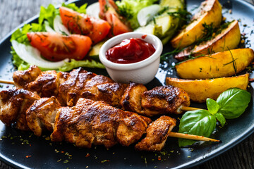 Fried souvlaki, potatoes with fresh vegetables 