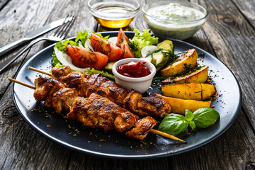 Fried souvlaki, potatoes with fresh vegetables 