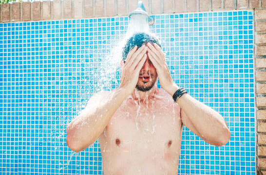 Young man having a shower before pool
