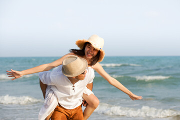 Happy Couple  giving piggyback ride  on beach, happy couple dating on beach 