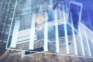 Forex graph hologram on table with computer background. Multi exposure. Concept of financial...