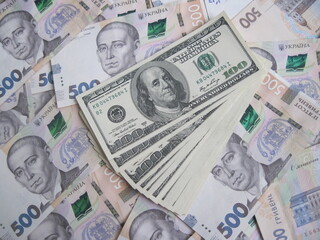 Financial background with a lot of paper banknotes of USA 100 dollars and Ukraine 500 hryvnia is great for editorial publication about money exchange. 