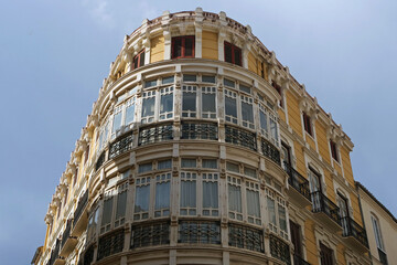 Close-up of the upper part of an old deceasing but beautiful house with a round corner in Malaga, Spain, Europe
