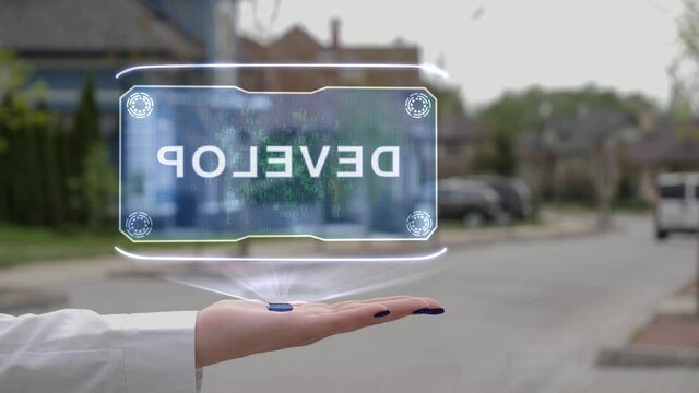 Female hand showing conceptual hologram with Develop text. Unrecognizable woman in white holds future holographic technology on the background of a street with private houses