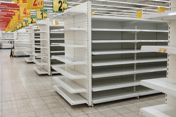 Empty shelfs in the supermarket. At the top, Polish prices and subtitles. © Dziurek
