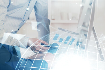 Double exposure of world map hologram with man working on computer on background. Concept of worldwideweb.