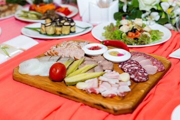 Sausages, cold cuts, dishes on a white banquet table