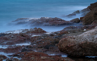 sea water hitting the shore stones with silk effect