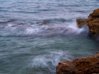 sea water hitting the shore stones with silk effect