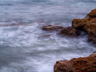 sea water hitting the shore stones with silk effect