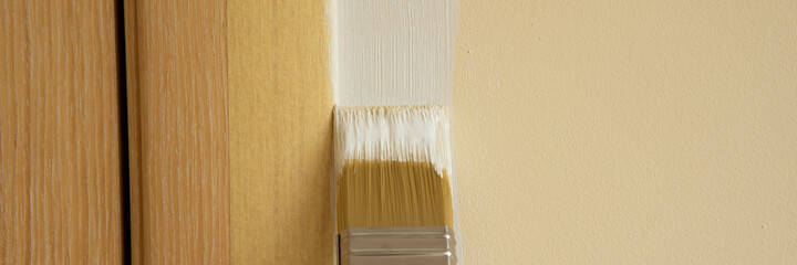 The hand with a brush paints from white color