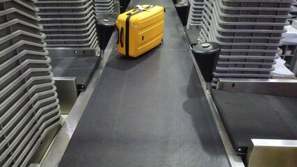 Luggage baggage bag after check-in desk counter in airport going on belt trolley. 4L footage clip