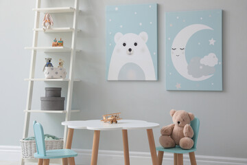 Children's room interior with table and cute pictures on wall