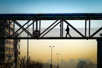 Pedestrian bridge with polluted Tehran capital city in background, Iran