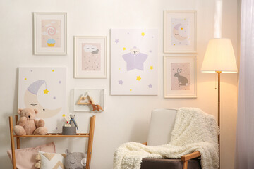 Fototapeta na wymiar Stylish child's room interior with comfortable armchair and beautiful pictures