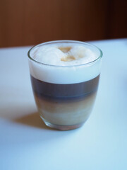 picture of a cup of coffe with milk into a white table