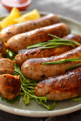 Grilled sausages with lemon and ketchup. Bavarian sausages with herbs and rosemary. Closeup. Vertical view