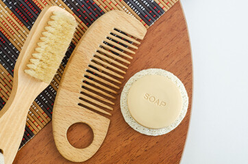 Bar of soap, wooden hair brush and body massage brush. Eco friendly toiletries. Natural beauty treatment, skin-care or zero waste concept. Top view, copy space.