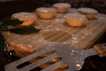 Fototapeta na wymiar Christmas fruit mince pies on wooden board with spatula