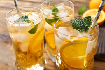 Delicious refreshing drink with orange slices on table, closeup