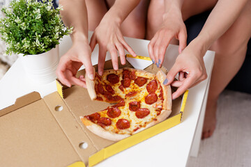 close up of female hands taking pizza slices