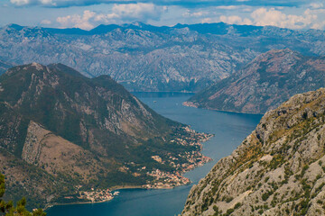 Naklejka na ściany i meble Bay of Kotor from the heights. View from Mount Lovcen to the bay. View down from the observation platform on the mountain Lovcen. Mountains and bay in Montenegro. The liner near the old town of Kotor.