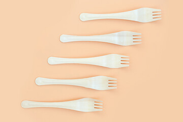 Disposable wooden forks on orange background