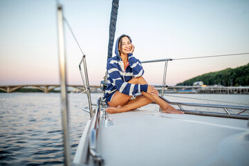Beautiful girl resting on a yacht at sunset