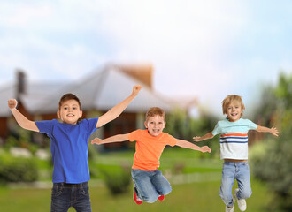 Obraz premium Happy boys jumping near house. School holidays