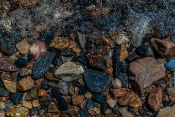 bright colored blue gold small pebbles in clear water sparkles in the sun, lake baikal