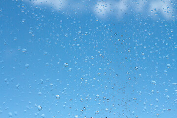 Naklejka na ściany i meble water drops on glass against blue sky