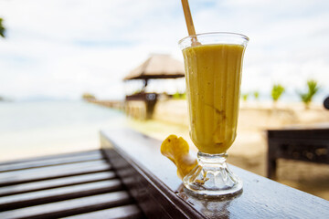 Mango juice on in front of the tropical sea
