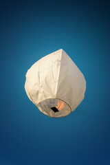 Sky Lantern in day light. White color thai sky lantern floating in blue sky.