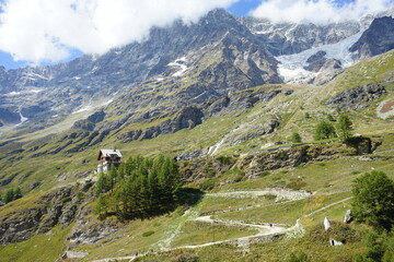 Fototapeta na wymiar Sentiero di montagna immerso in uno spettacolare panorama alpino ai piedi del monte Cervino Italia
