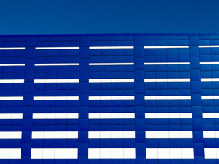 Background of blue and white facade tiles of modern building. Blue tile wall texture background