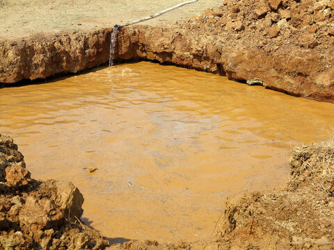 Dig a ditch in clay soil and fill with water. Preparatory work for the competition with obstacles. The pit is filled with water.