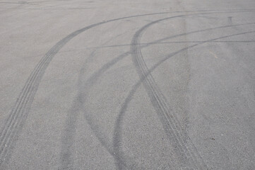 Bright tire tracks on asphalt drifting into a curve
