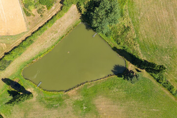 A pond in the middle of fields

Aerial view of a pond in the middle of fields in the Taunus / Germany with wonderful bathing weather