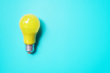 yellow light bulb isolated on blue background with copy space , innovation and idea concept