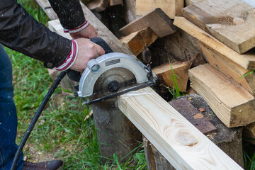 Sawing a wooden Board with an electric grinder.