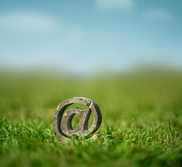 Beton @-Sign Email Zeichen auf der Wiese im Gras