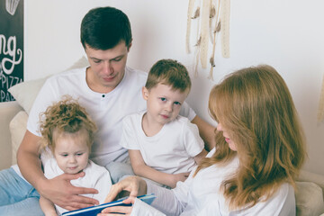 Young parents reads with their children. Happy family concept