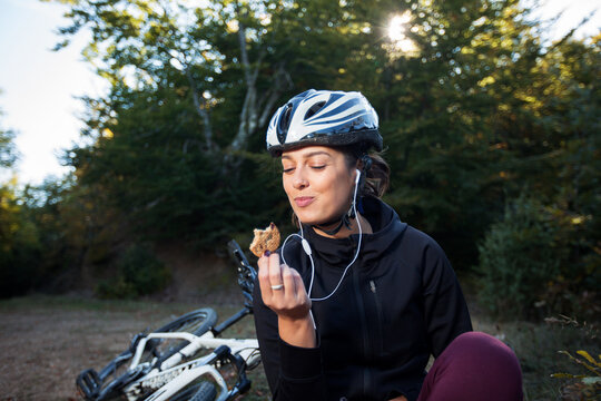 Young Female Cyclist Eating Integral Biscuits