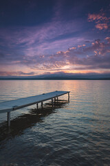 Small boat dock on Lake Bernard as morning dawns.  Vivid color paint the sky and reflect off of the lake.