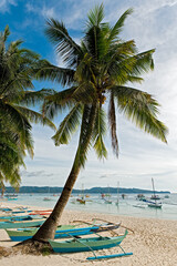 Scenic view of palm trees and many small fishing boats on the empty sandy White Beach on Boracay Island, Visayas, Philippines, Asia 