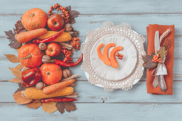 Autumn table setting, menu composition, vintage cutlery, sliced pumpkin. Thanksgiving food, healthy and fresh, top view, flat lay, copy space. Fallen leaves, fruits, vegetables, wooden table.