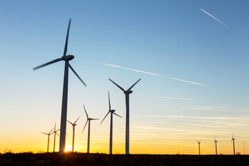 Wind Turbines at Dusk. Landscape sunset with windmills. Renewal source of electricity. Wind turbines field new technology for clean energy on mountain, sunset view with colorful twilight on sky