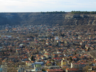 View of the roofs of red tiles from a bird's eye view. Picturesque bright roofs landscape of a small town in a mountain valley. Traditional tiled roof of a European city, Bulgaria.
