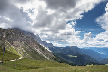 Odle mountain massif, Funes valley below & Poma Step as seen from the alpine pasture of Genova refuge on a cloudy, before-rain early evening, Dolomites, Trentino, Alto-Adige, South Tyrol, Italy.