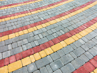 Close-up paving slabs by mosaic. Road paving, construction. Tessellated sidewalk tile. Colored...
